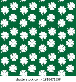 Vector seamless pattern of flat white clover shamrock isolated on green background