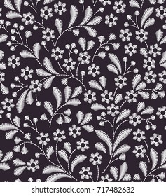 Vector seamless pattern. Floral background in vintage style. Decorative embroidery flowers. Ornament for textiles on black background. Small white flowers. The elegant the template for fashion prints.