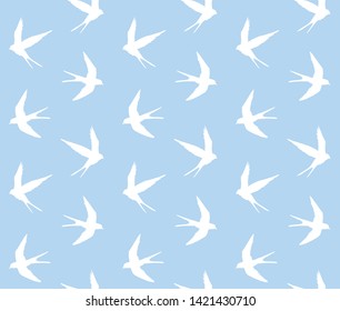 Vector seamless pattern of flying swallow bird silhouette isolated on pastel blue background 