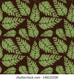 Vector seamless pattern with green leaves on the brown background