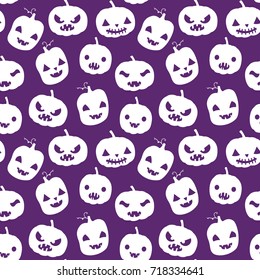 Vector seamless pattern with Halloween pumpkin silhouettes in white color with carved faces on purple background for scrapbook, invitations and textile