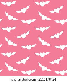 Vector seamless pattern of hand drawn heart with wings silhouette isolated on pink background