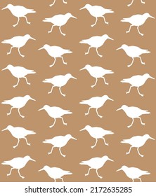 Vector seamless pattern of hand drawn sandpiper bird silhouette isolated on brown background