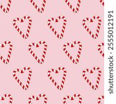 Vector seamless pattern with heart-shaped candy canes on a pink background