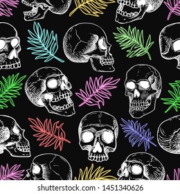 Vector seamless pattern with human skulls in inversion and colored palm leaves. Line art on a black background in the style of the tattoo.