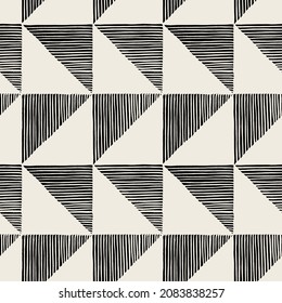 Vector seamless pattern. Linocut abstract triangles. Graphic hand drawn background. Stamped monochrome texture. Repeating print with hatched triangles.