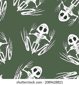 Vector seamless pattern with skeletons of frogs on a green background