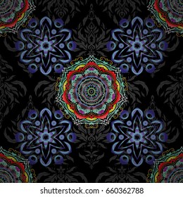 Vector seamless pattern of traditional ornamental background with blue, yellow and violet circular mandala, stars and snowflakes elsments on a black backdrop.