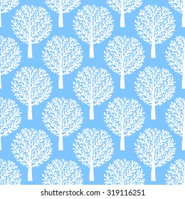 Vector seamless pattern with trees silhouettes and leafs in blue and white colors for fall winter fashion or Christmas wrapping paper. Chic, elegant, natural print with woods. Retro style wallpaper.