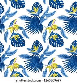 Vector  seamless pattern of tropical blue palm leaves, monstera  leaves  and coral flowers of the bird of paradise (Strelitzia) plumeria on a light blue background. Wallpaper trend design.