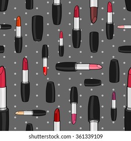 Vector seamless pattern with varicolored lipsticks and caps of different size rotated in different directions on gray background with polka dot