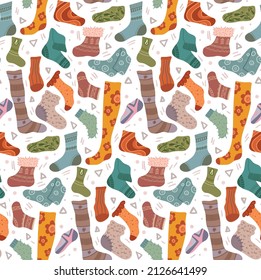 Vector seamless pattern with various cozy knitted socks and stockings on white background. Texture with hand drawn cartoon clothes and doodle decorations in warm colors with ornaments
