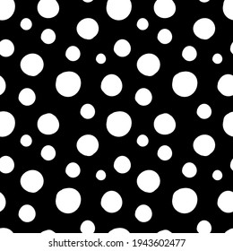 A Vector seamless pattern of white hand-drawn circles polka dot isolated on a black background