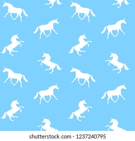 Vector seamless pattern of white unicorn silhouette isolated on pastel blue background 