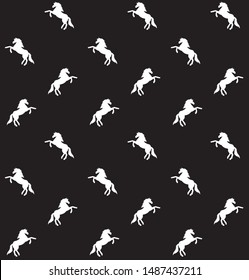 Vector seamless pattern of white unicorn silhouette isolated on black background
