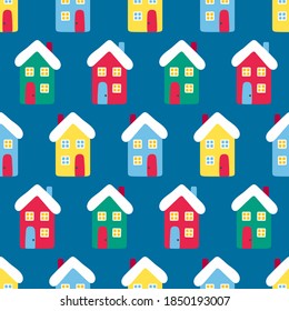 Vector seamless pattern wih houses. Cute winter illustration in flat style. Red, green, yellow, blue and white colors. Winter design background. Bright elements on blue background.