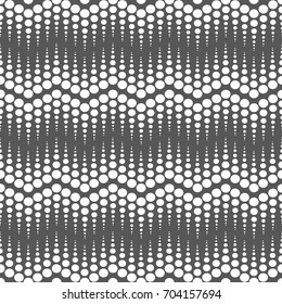 Vector seamless pattern.Halftone dots on black background.Monochrome geometric texture with repeated dots of different sizes.