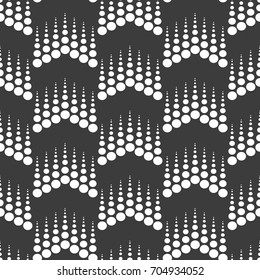 Vector seamless pattern.Halftone dots on black background.Monochrome geometric texture with repeated dots of different sizes.