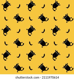 Vector seamless repeating pattern. Halloween illustration with black cats and bats on yellow background. Suitable for printing and wall decoration.