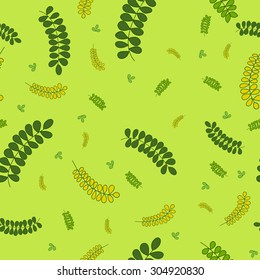 Vector seamless texture with the image of green acacia leaves, dark green and yellow colors on a light green background