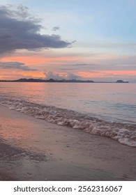 Vector seascape during sunset, with soft pastel hues of pink, orange, and blue blending across the sky and reflecting on the calm water. 