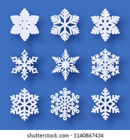 Vector set of 9 white Christmas paper cut snowflakes with shadow on blue background. New year and Christmas design elements