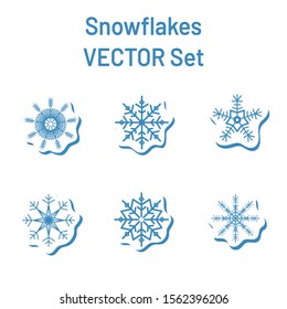 Vector set of blue geometric snowflake stickers with shadow on a white background.