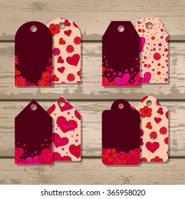 Vector set of gift tags with hearts and flowers for Valentine's Day on a wooden background. In red and beige colors.