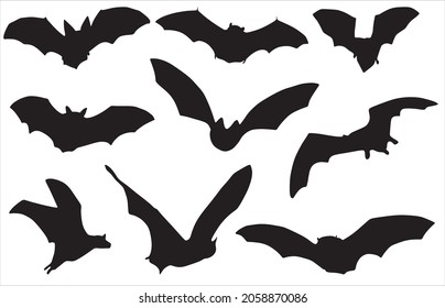 Vector set of silhouettes of bats. Shadows of flying animals. Wingspan. Fanged beasts