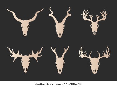 Vector set of six hand drawn gold silhouettes skulls of horned animals: stag, roe deer, moose and antelope on black background. For you design, print, tattoo or magic craft.