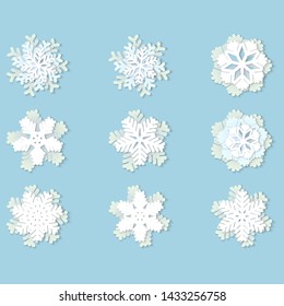 Vector set of white Christmas paper snowflakes with shadow on blue background. Holiday, New year and Christmas design elements