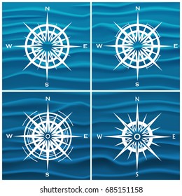 Vector set of wind roses over blue waves background. Vector illustration.