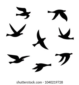 Vector silhouette of a flock of birds. Set of black isolated flat contours of flying birds. Design element for logo, print, card, flyer, fabric, poster.
