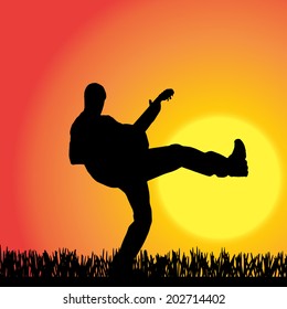 Vector silhouette of a man with guitar at sunset.