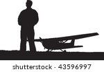 Vector silhouette of a man standing on a airstrip with a plane in the background.