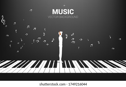 Silueta vectorial del hombre parado con la llave del piano con nota musical voladora . Concepción de música piano de fondo y recreación.