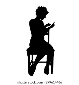 Vector silhouette of a woman who is sitting on a white background.