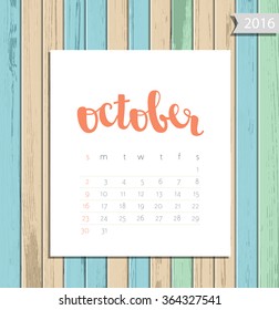 Vector simple modern calendar October 2016 on a colorful wooden texture background. Calligraphy lettering month name