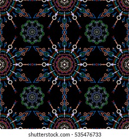 Vector sketch. Good for greeting card for birthday, invitation or banner. Orange, blue and green seamless pattern on a black background. Decorative symmetry arabesque. Medieval floral royal pattern.