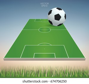 Vector soccer ball and soccer field with green grass field area and soft sky background.