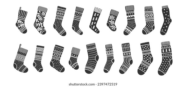 Iconos de los vectores en calcetines. Ilustración de adorables accesorios de punto, siluetas negras con adornos blancos de Navidad. Ropa para hombres, mujeres y bebés.