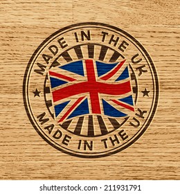 Vector Stamp With Flag Of GB, Circular Lettering Made In The UK On Wooden Background