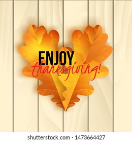 Vector thanksgiving greeting card with hand lettering label - enjoy thanksgiving day - and autumn realistic oak leaves on wood background.