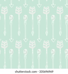 Vector tribal seamless pattern in boho style with aztec arrows on light green background