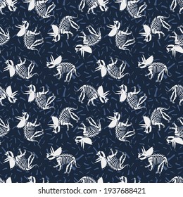 Vector triceratops seamless pattern with bones. Cute dinosaur skeletons on blue background.