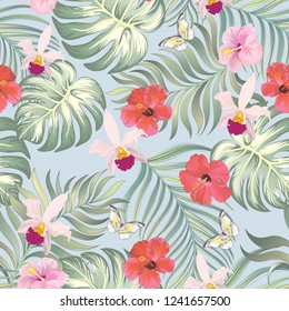 Vector tropical sin costuras con flores de hibisco y hojas de palma.