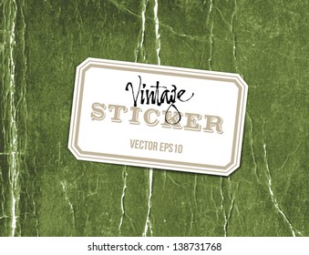 Vector vintage crumpled paper sticker over old distressed green cardboard background