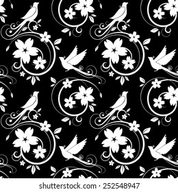 Vector. White birds and blossoms silhouettes. seamless pattern on black background.