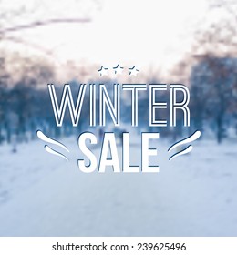 Vector winter blurred illustration with snow, trees and typography text "Winter sale" 