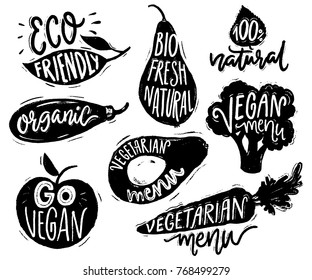 Emblemas de menu vegetariano e adesivos para café e restaurantes. Texto vegano em rótulos vegetais pretos para produtos naturais. Brócolis, abacate, cenoura desenhada à mão silhuetas com letras